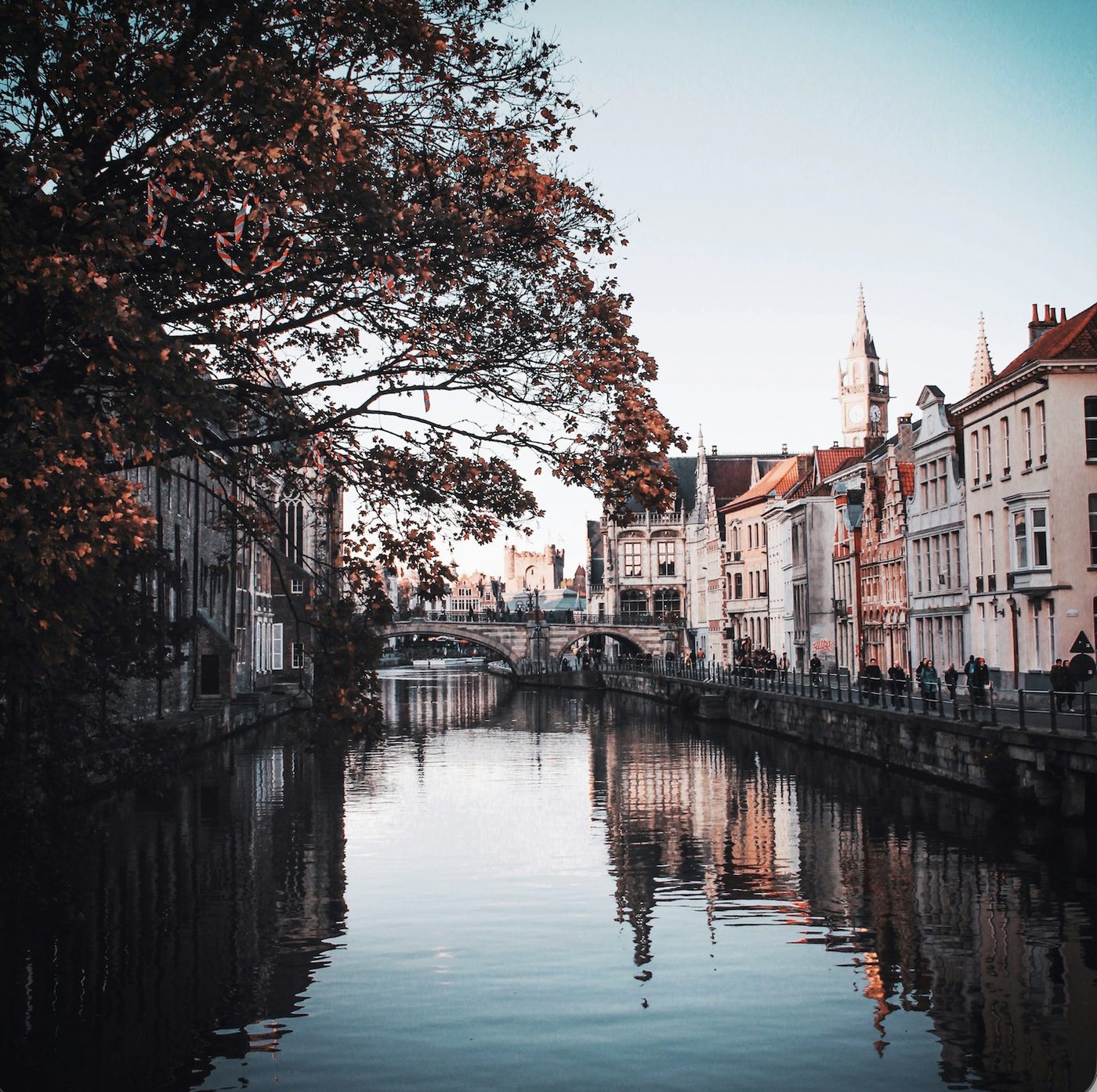 Historic façades reflected in a canal in Ghent in autumn