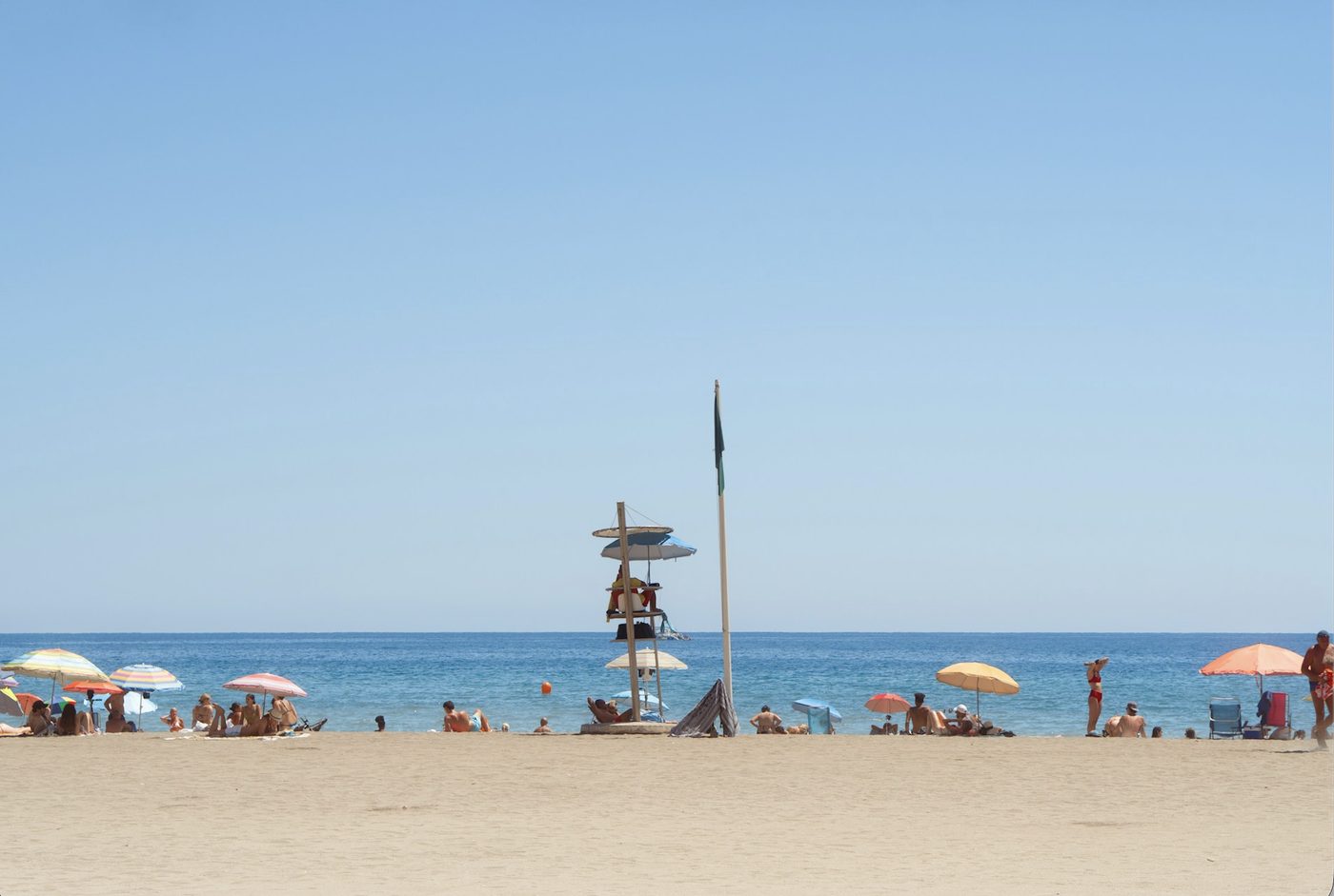 Sunny beach with colorful parasols on the coast of Málaga