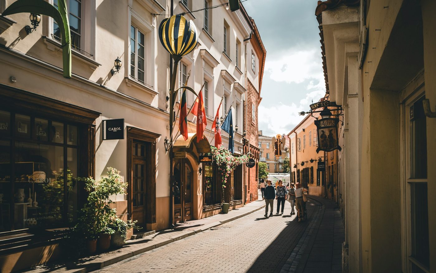 Sunny cobbled street with flags in the old town of Vilnius