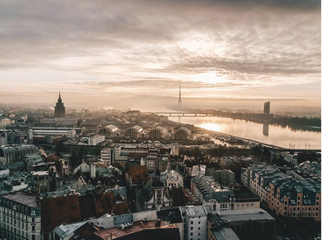 Uitzicht over de daken van Riga met de rivier de Daugava en een gouden zonsopkomst