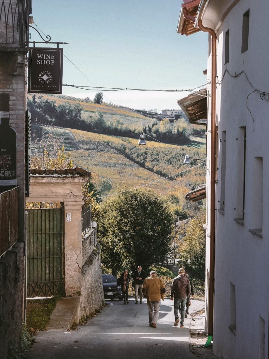 Straatje met een wijnwinkel en uitzicht op de wijnvelden van Piemonte