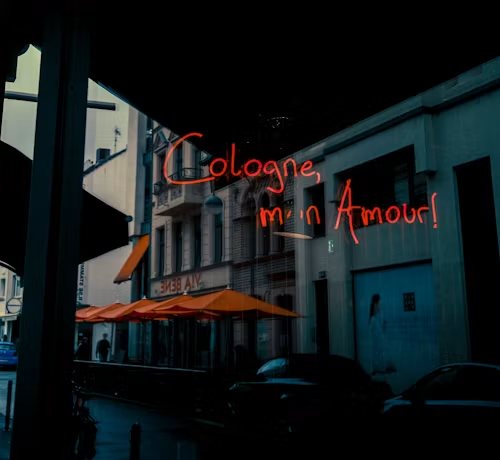 Rode neonletters met de tekst Cologne, mon Amour boven een straat in Keulen